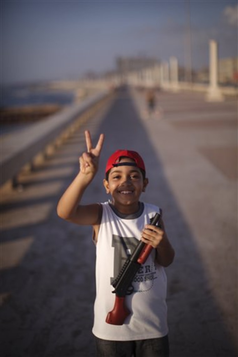 Mansur Mohamed, 9, makes the victory sign at the seaside of the rebel-held town of Benghazi, Libya, Thursday, Aug. 11, 2011. 